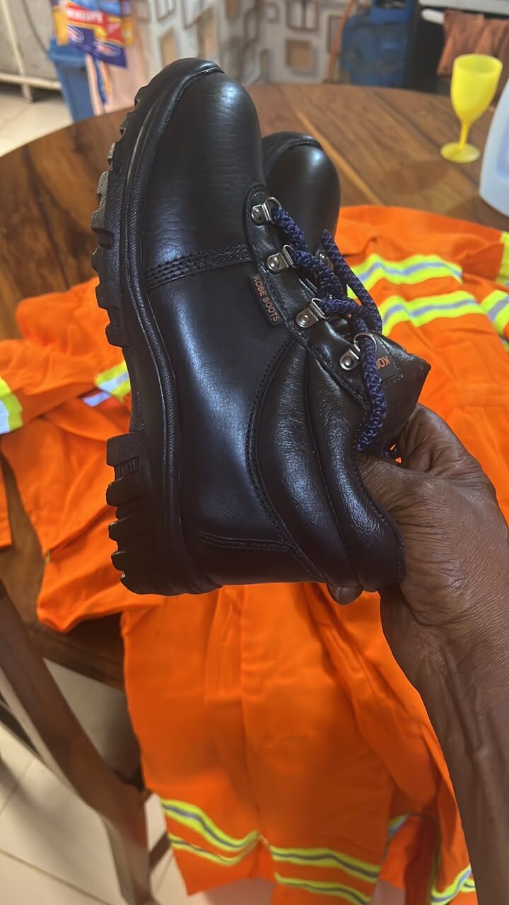 Black lace-up boot held in hand, side view