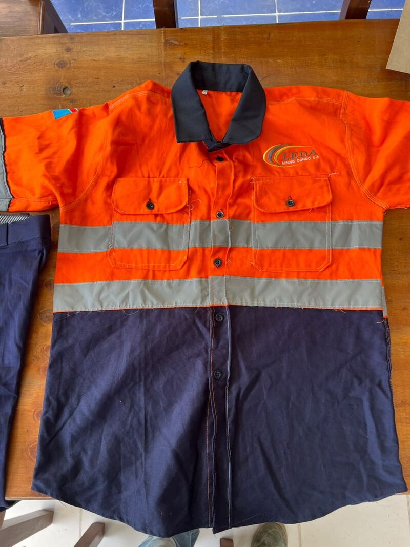 Orange and navy work shirt with reflective bands, laid flat